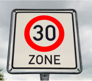 A white 30 mph speed zone sign.
